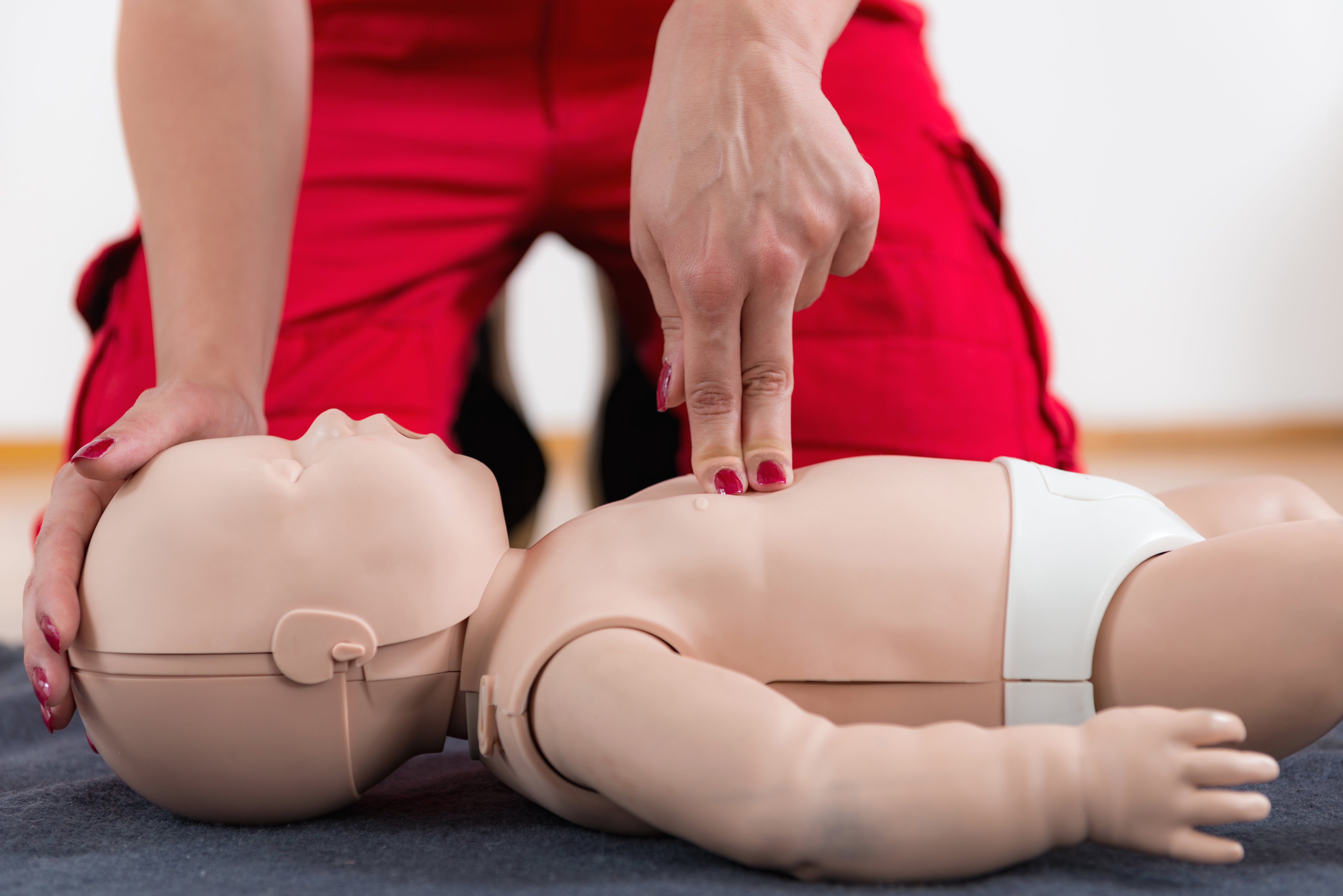 CPR recertification training session with instructor reviewing proper techniques