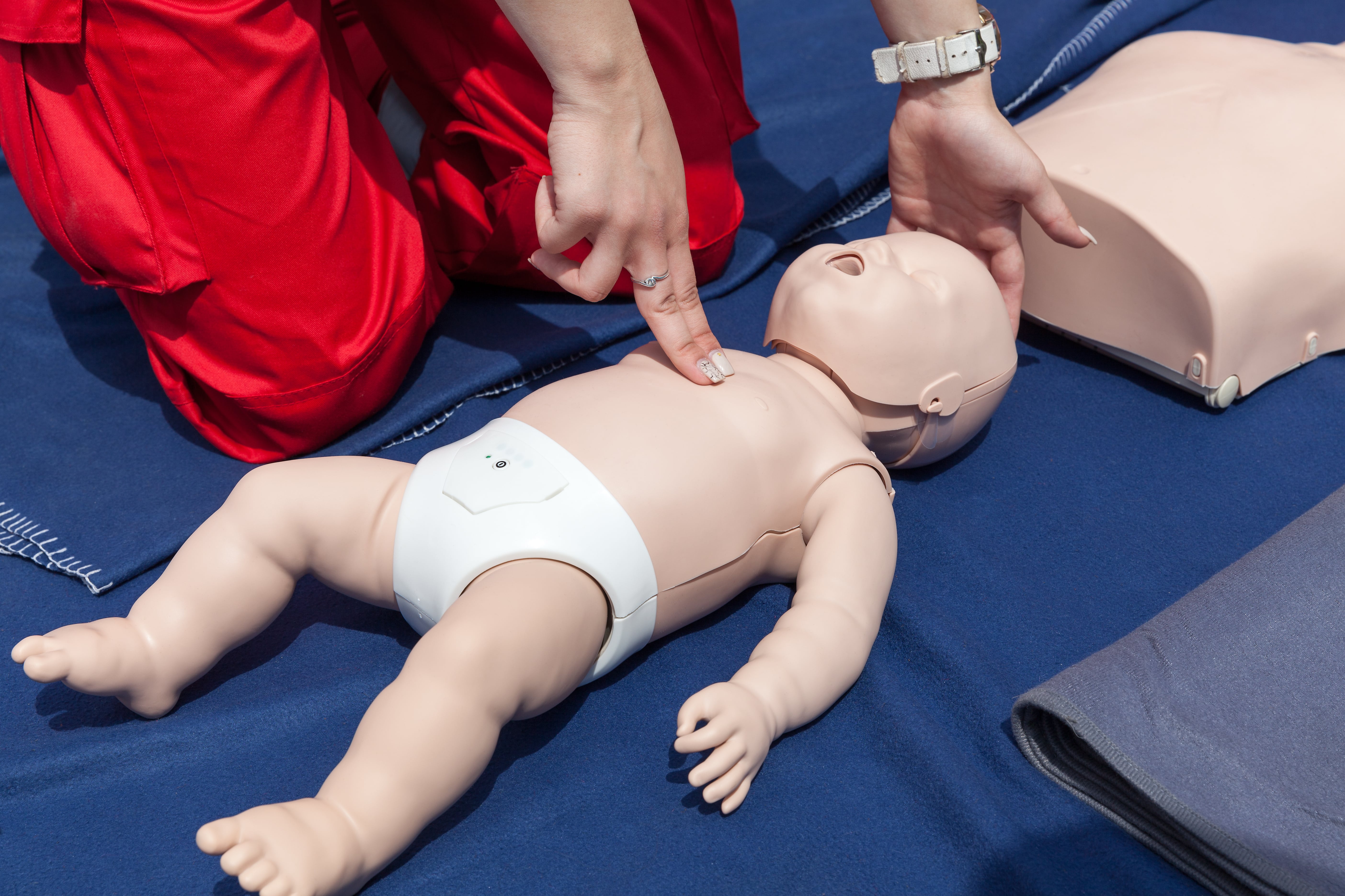 First Aid Training classroom with instructor demonstrating CPR techniques to students